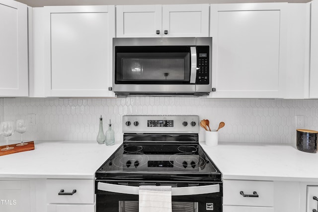 kitchen with light countertops, appliances with stainless steel finishes, decorative backsplash, and white cabinetry
