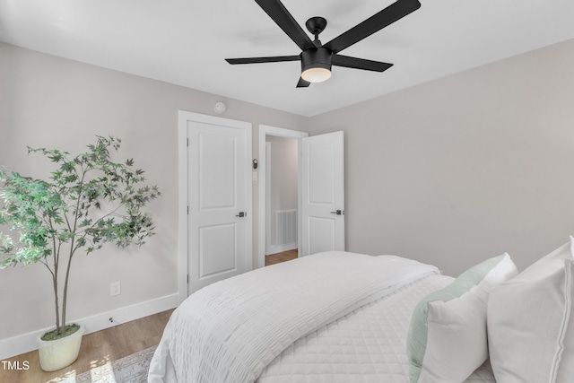 bedroom featuring baseboards, light wood-style flooring, ceiling fan, and visible vents