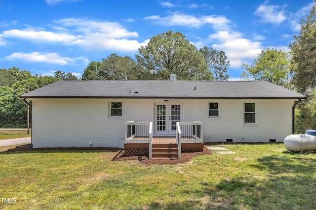 rear view of property featuring brick siding, a deck, crawl space, french doors, and a lawn