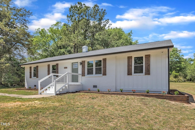 ranch-style home with brick siding, board and batten siding, crawl space, a front yard, and a chimney