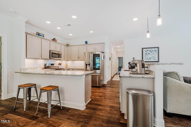 4072 Mackenzie Dr, Haw River, NC 27258 - kitchen featuring stainless steel appliances, a peninsula, dark wood finished floors, light stone countertops, and recessed lighting