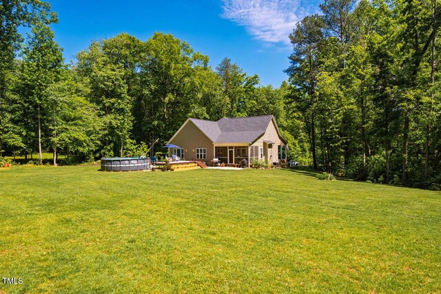 4072 Mackenzie Dr, Haw River, NC 27258 - rear view of property featuring a yard, an outdoor pool, a forest view, and a deck