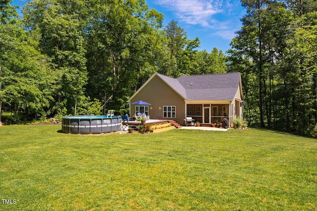 4072 Mackenzie Dr, Haw River, NC 27258 - rear view of house with a sunroom, a lawn, an outdoor pool, and a shingled roof