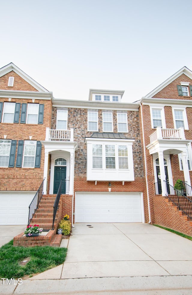 multi unit property featuring concrete driveway, brick siding, and a garage