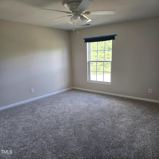 carpeted spare room featuring baseboards, ceiling fan, and visible vents