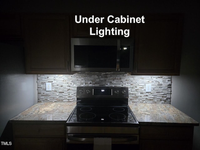kitchen with electric range oven, stainless steel microwave, and tasteful backsplash