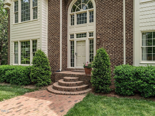 entrance to property featuring brick siding