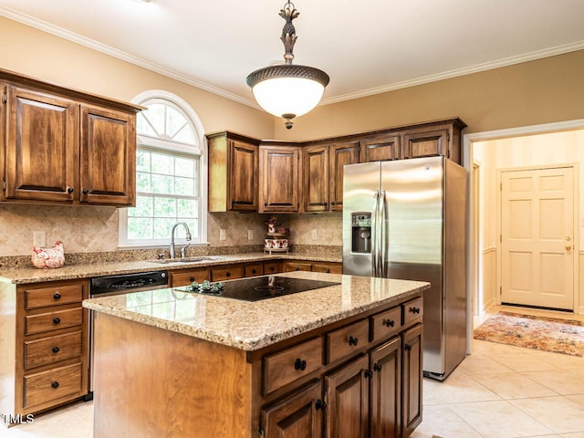 kitchen featuring decorative backsplash, a sink, light stone counters, black electric stovetop, and stainless steel fridge