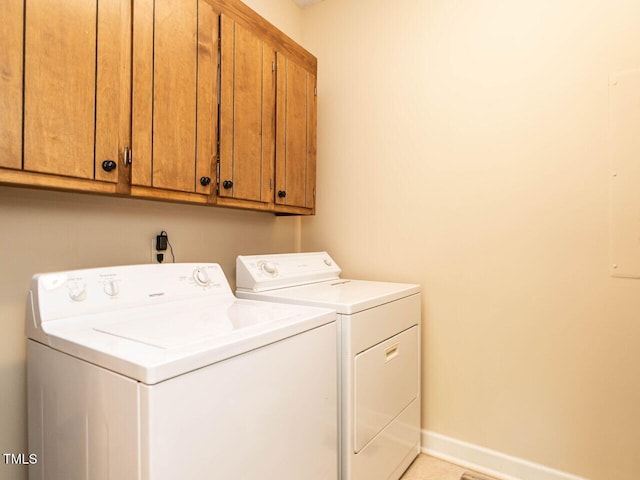 laundry area featuring separate washer and dryer, baseboards, and cabinet space
