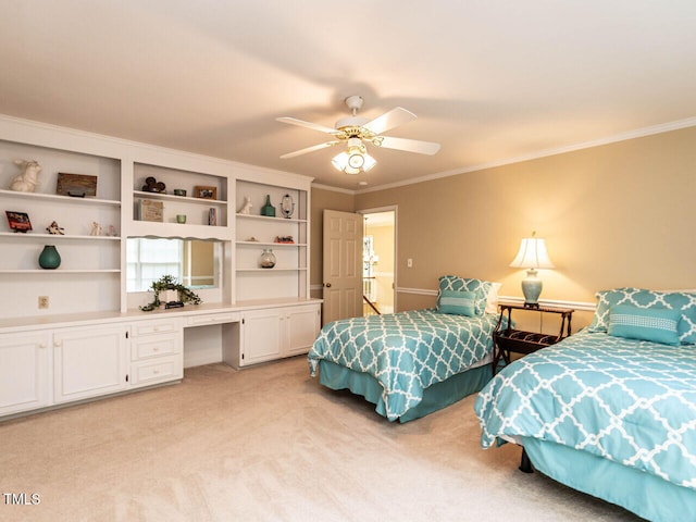 bedroom with built in study area, ornamental molding, a ceiling fan, and light colored carpet