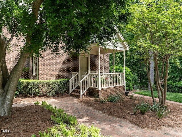 exterior space with covered porch and brick siding