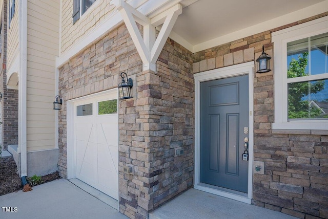 doorway to property with a garage and covered porch