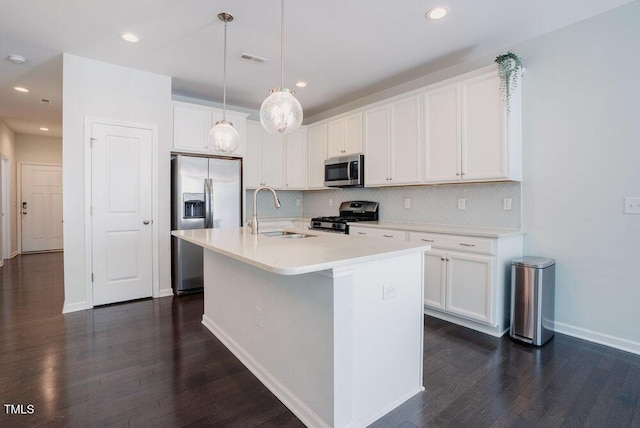 kitchen featuring tasteful backsplash, dark wood finished floors, a sink, white cabinets, and stainless steel appliances