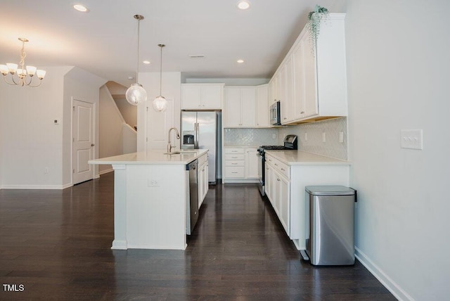kitchen featuring white cabinets, dark wood-style flooring, stainless steel appliances, baseboards, and backsplash