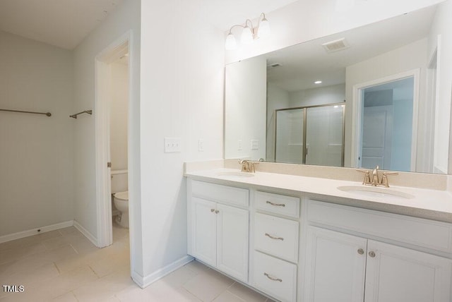 bathroom featuring double vanity, tile patterned flooring, a shower stall, a sink, and toilet