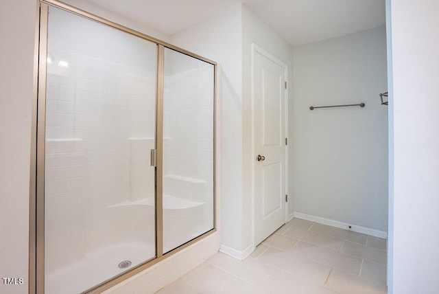 full bath with tile patterned floors, a shower stall, and baseboards