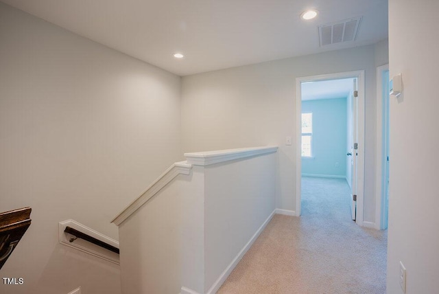 hall featuring visible vents, carpet floors, baseboards, recessed lighting, and an upstairs landing