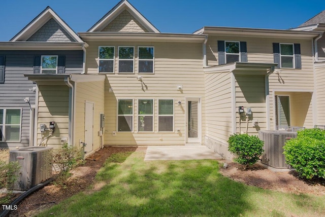back of house with central AC unit, a patio area, and a yard