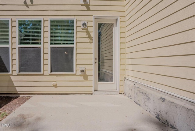 view of exterior entry featuring a patio area