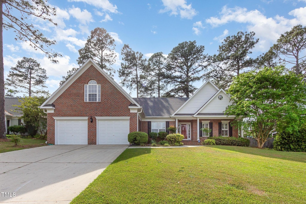 view of front of property featuring a garage, driveway, a front lawn, and brick siding