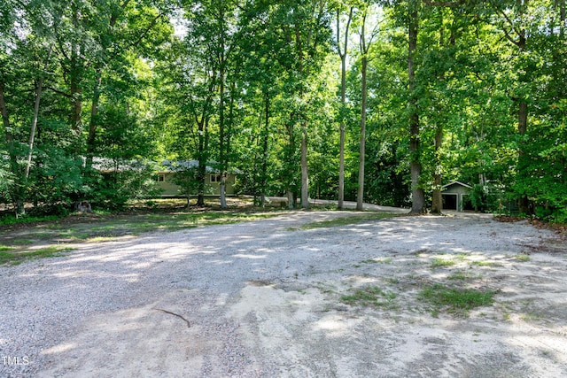 5213 Tomahawk Trl, Raleigh, NC 27610 - view of dirt / gravel driveway with a view of trees