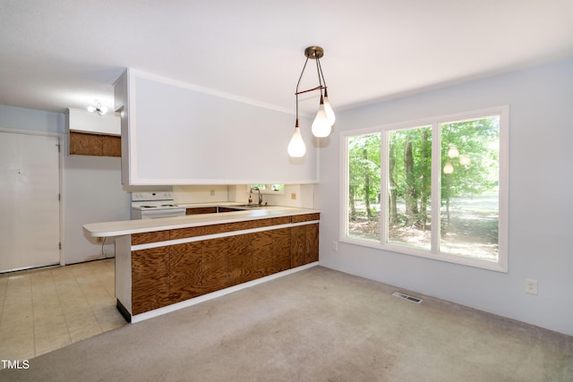 5213 Tomahawk Trl, Raleigh, NC 27610 - kitchen featuring white range with electric cooktop, a sink, a peninsula, decorative light fixtures, and light countertops