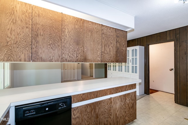 5213 Tomahawk Trl, Raleigh, NC 27610 - kitchen featuring dishwasher, wooden walls, light floors, light countertops, and a peninsula