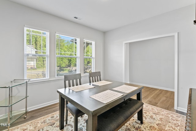 dining room with baseboards, visible vents, and wood finished floors