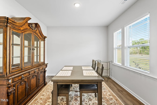 dining area with dark wood finished floors and baseboards