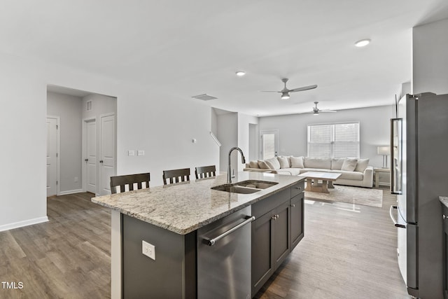 kitchen featuring ceiling fan, visible vents, a sink, open floor plan, and appliances with stainless steel finishes