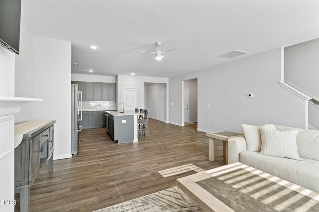 living room featuring visible vents, recessed lighting, ceiling fan, dark wood-style flooring, and baseboards