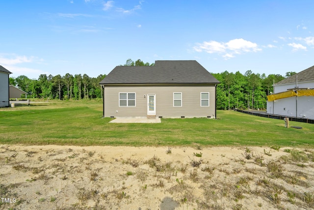 rear view of property with a lawn, a patio, and crawl space