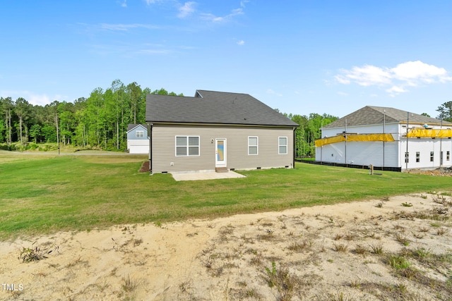 rear view of house featuring a patio area, crawl space, and a lawn