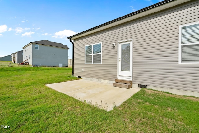 back of property with a yard, entry steps, a patio, and crawl space