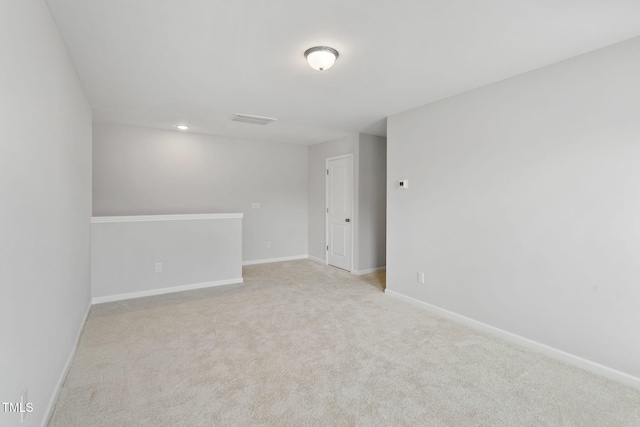 carpeted empty room featuring visible vents and baseboards