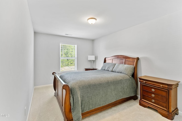 bedroom featuring baseboards, visible vents, and light colored carpet