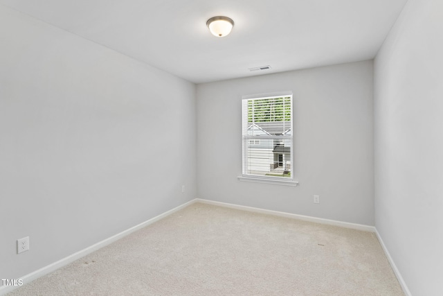 unfurnished room with light colored carpet, baseboards, and visible vents