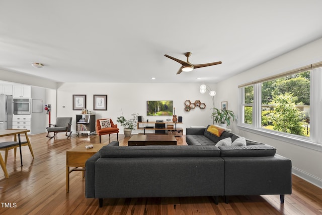 living area with a ceiling fan and hardwood / wood-style floors