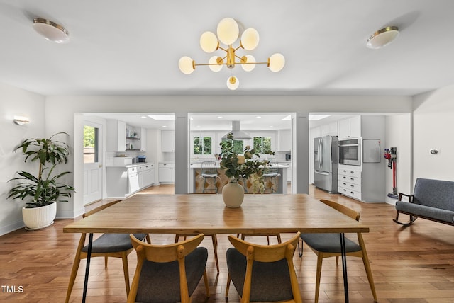 dining area featuring a notable chandelier and light wood finished floors