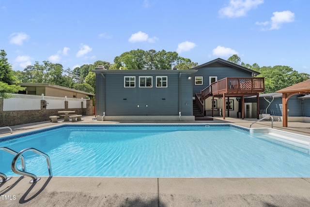 view of swimming pool with a wooden deck, fence, stairs, and a fenced in pool