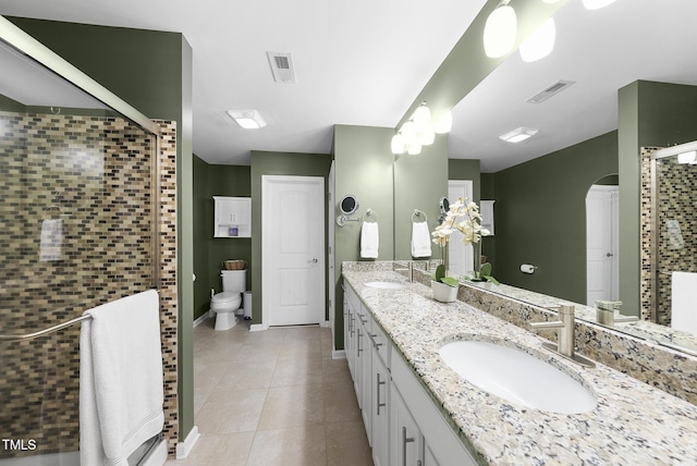 bathroom featuring a sink, tile patterned flooring, a stall shower, and visible vents