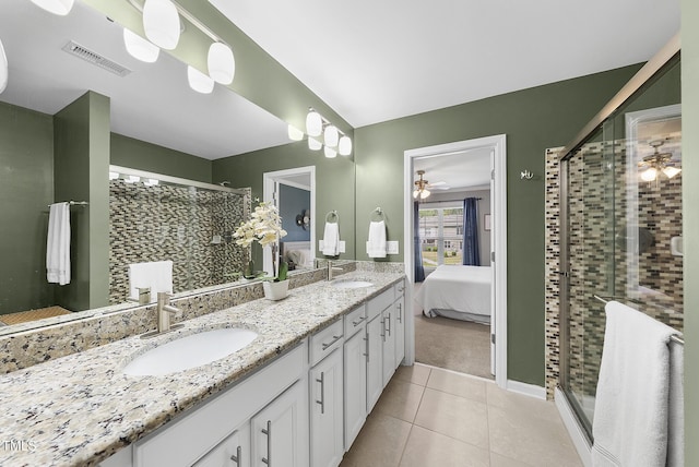 ensuite bathroom with a sink, a shower stall, a ceiling fan, and visible vents