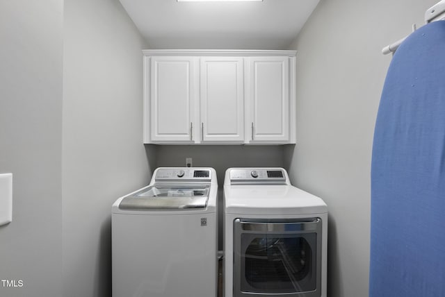laundry area featuring washer and clothes dryer and cabinet space