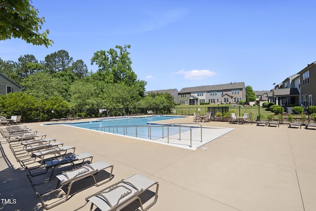 pool featuring fence, a residential view, and a patio area