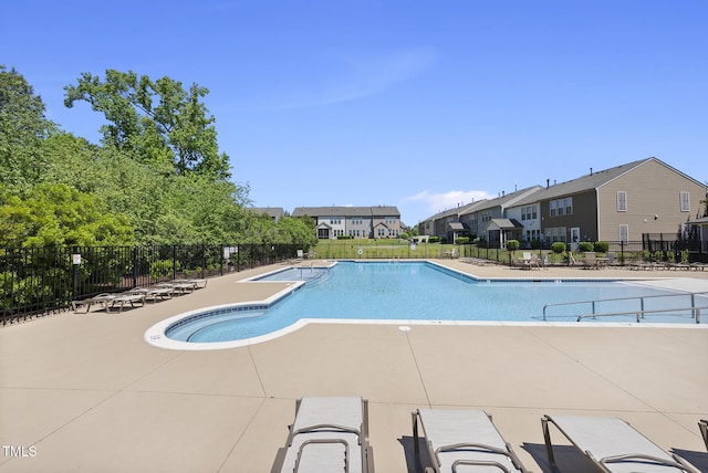 pool featuring a patio, fence, and a residential view