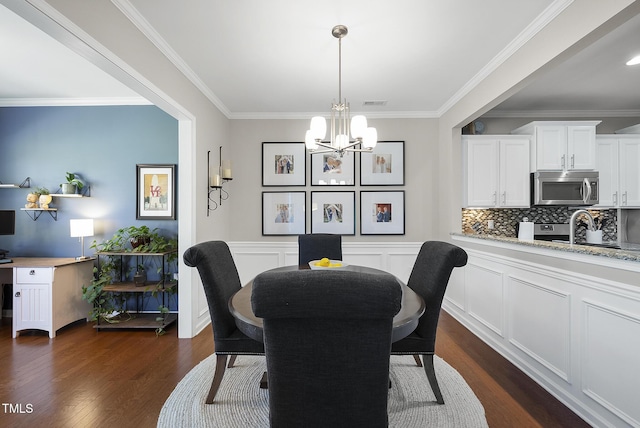 dining room featuring crown molding, dark wood-style flooring, a chandelier, and visible vents