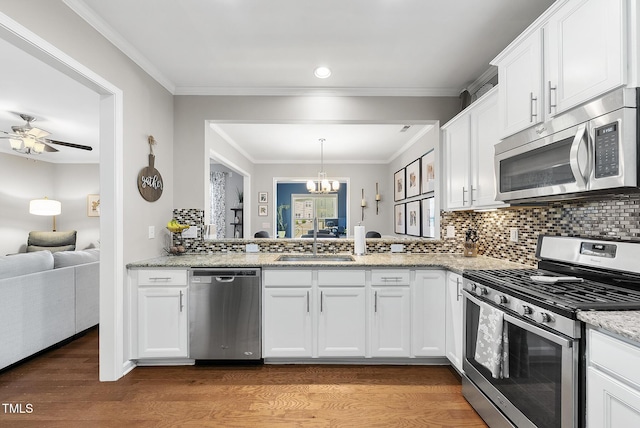 kitchen with white cabinetry, appliances with stainless steel finishes, a sink, and light wood-type flooring