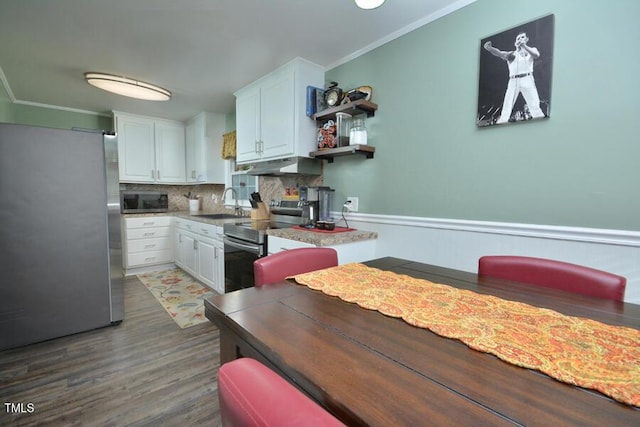 114 Short St E, Hillsborough, NC 27278 - kitchen with dark wood-style flooring, crown molding, appliances with stainless steel finishes, under cabinet range hood, and white cabinetry