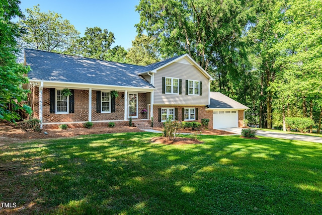 split level home with brick siding, an attached garage, driveway, and a front yard