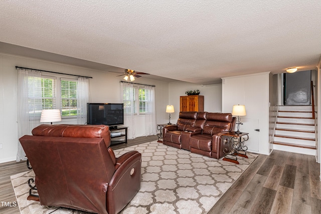 living area featuring stairs, a textured ceiling, and wood finished floors